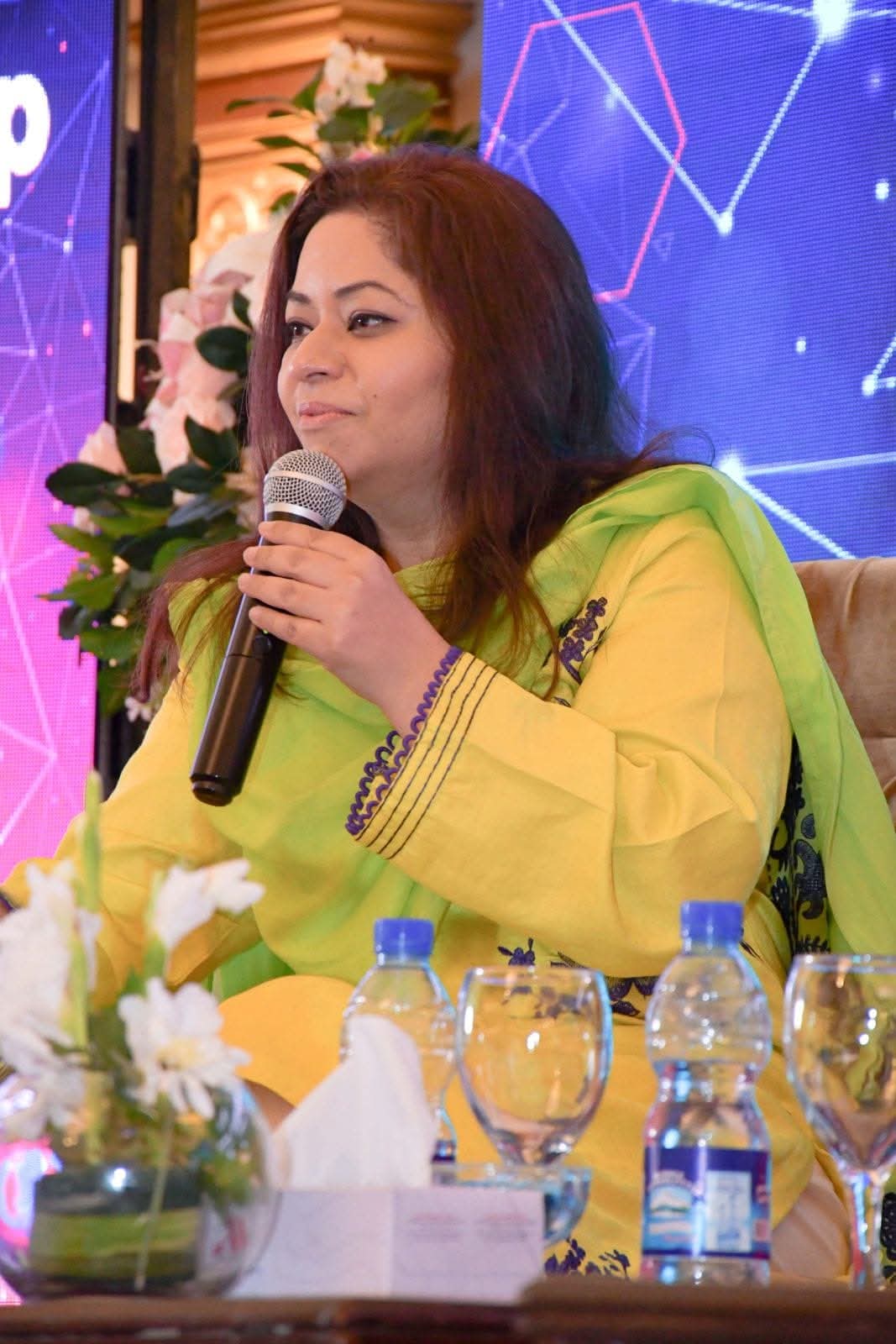 Fajer Rabia Pasha holding a microphone at an event